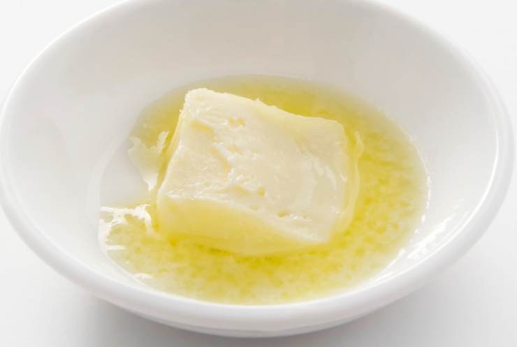 Iniziamo lasciando ammorbidire il burro a temperatura mentre ci dedichiamo a sbriciolare i biscotti: possiamo frullarli per qualche secondo o tritarli con un matterello. Intanto sciogliamo a bagnomaria il cioccolato bianco;