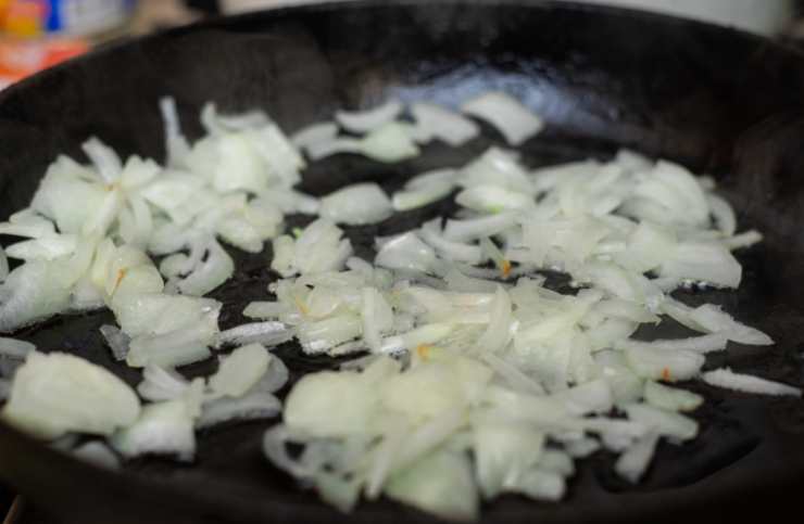 Iniziamo rosolando la cipolla tritata in un tegame con un filo d’olio, quindi uniamo il riso e saltiamo per qualche minuto poi accorpiamo i primi coppini di brodo caldo;