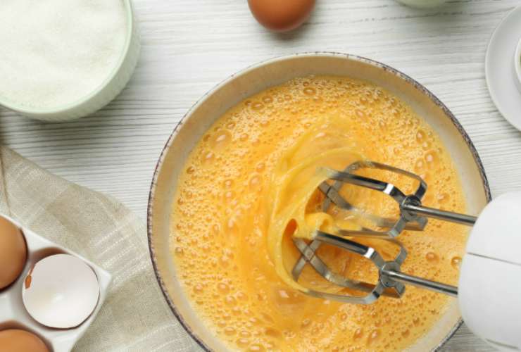 Per prima cosa lavoriamo le uova con lo zucchero fino a ottenere un composto spumoso, quindi aggiungiamo la farina e l’amido setacciati, il lievito, la vanillina e la buccia di limone grattugiata. Accorpiamo anche le gocce di colorante giallo e mescoliamo;