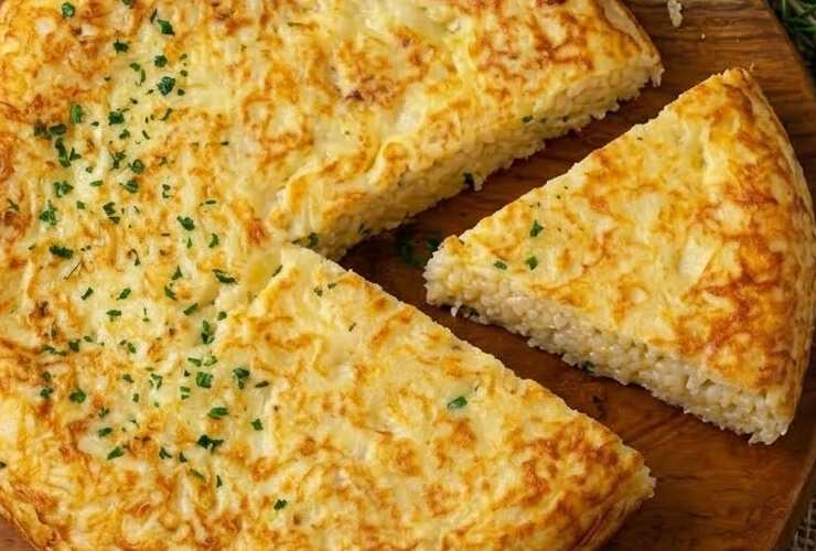 Quando la padella sarà ben calda riversiamo il composto di riso e uova e livelliamo. Copriamo con un coperchio e lasciamo cuocere fino a dorare prima un lato. Capovolgiamo e cuociamo anche l’altro lato. Una volta pronta la frittata lasciamo assestare qualche minuto prima di tagliare a fette.