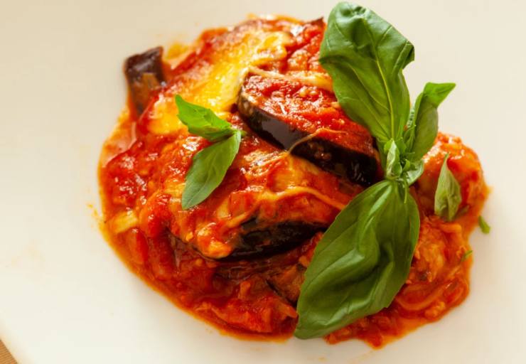 Prendiamo una teglia da forno e sul fondo versiamo un coppino di sugo di pomodoro. Adagiamo metà delle fettine di melanzane e poi il formaggio light tagliato a pezzetti. Ricopriamo con altro sugo di pomodoro e facciamo il secondo giro di melanzane. Ricopriamo col pomodoro rimasto e spolveriamo il parmigiano grattugiato. Cuociamo a 180 gradi per 20/25 minuti finché la parmigiana non sarà ben dorata.