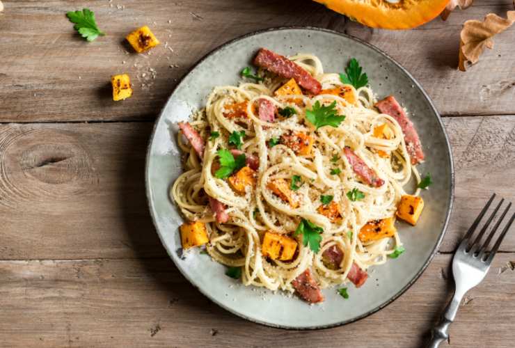 Controlliamo la zucca: quando è tenera schiacciamo una parte con la forchetta direttamente in padella e, appena pronta la pasta, scoliamo e riversiamo al suo interno. Mescoliamo dopo aver aggiunto il parmigiano grattugiato e il guanciale e portiamo a tavola.