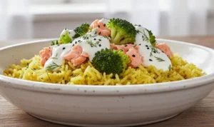 Bowl di riso basmati giallo alla curcuma cotto al microonde, servito con salmone, broccoli al vapore e salsa allo yogurt in una cucina luminosa stile shabby chic.