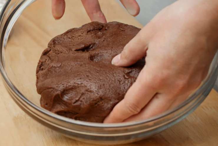 Versiamo il composto ottenuto su un piatto imburrato, livelliamo e lasciamo raffreddare a temperatura ambiente, poi mettiamo in frigorifero per almeno un’ora. Una volta che il composto sarà freddo e sodo, inumidiamo le mani o ungiamole con po’ di burro e stacchiamo dei pezzetti a cui daremo la forma di palline;