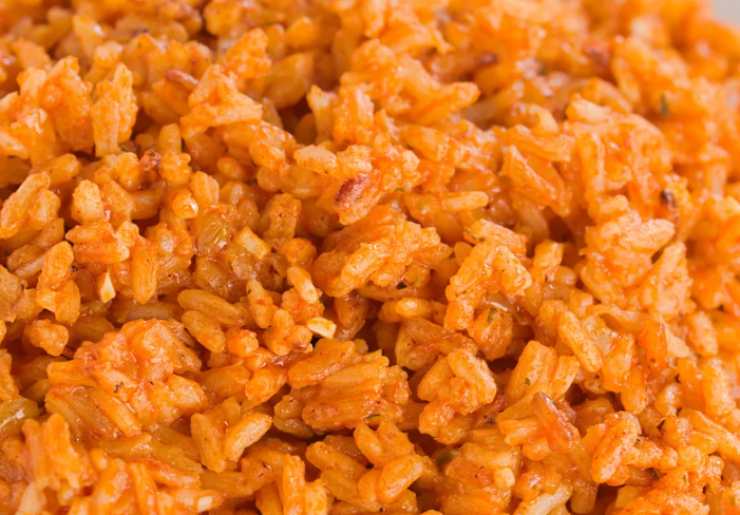 Cotto il riso insaporiamo con sale, pepe e parmigiano grattugiato, poi riversiamolo in una teglia foderata e livelliamo, lasciando raffreddare. Andiamo quindi a prelevare dei pezzetti, formiamo una pallina e schiacciamo con le mani. Al centro sistemiamo un pezzo di mozzarella e lavoriamo di nuovo per dare la forma di una pallina allungata;