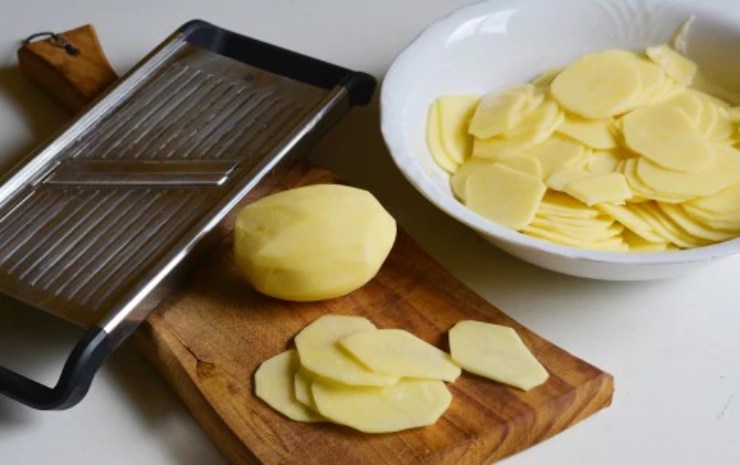 Tagliate le patate a fette molto sottili con una mandolina così cuoceranno insieme al pesce: mettetele direttamente in teglia con un giro d’olio extra vergine d’oliva e sale e mettetele in forno a 200 gradi per 10 minuti.