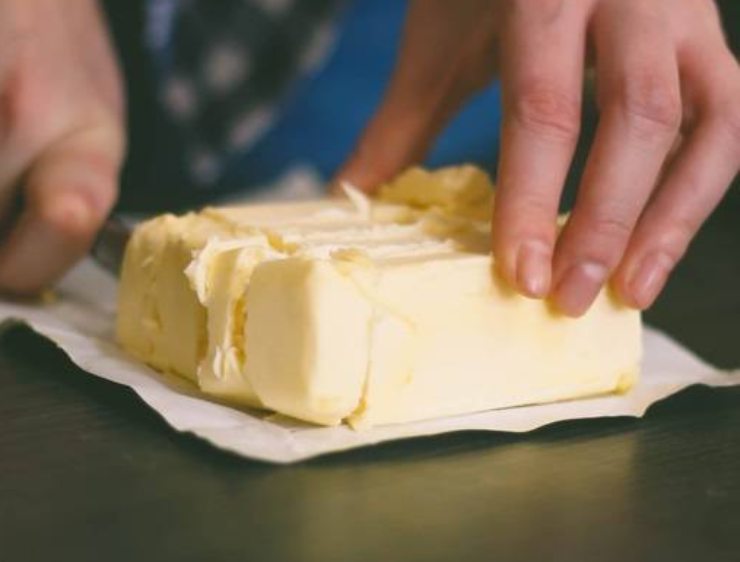 Quando l’impasto avrà raggiunto una certa consistenza, compattatelo impastando con le mani e portandolo verso il centro. Iniziate ad incorporare poco alla volta il burro morbido a pezzetti, fino a farlo assorbire del tutto. Trasferite il composto su una spianatoia leggermente infarinata, appiattitelo con le mani formando un rettangolo e cospargetelo con le gocce di cioccolato fondente.