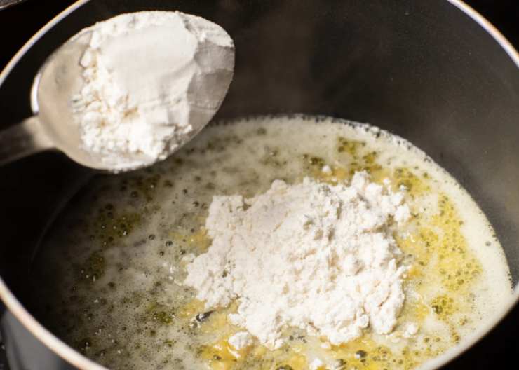 Andiamo ad accorpare all’olio la farina setacciata, usando una frusta a mano per mescolare ed evitare la formazione di grumi. Quando il composto sarà omogeneo accorpiamo il latte ormai caldo poco alla volta;