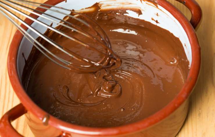 Tritiamo quindi il cioccolato sciogliamo a bagnomaria oppure nel microonde. Versiamo il latte condensato nella ciotola con i biscotti e il cacao, iniziando ad amalgamare il tutto con un cucchiaio;