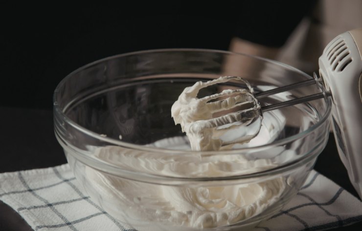 Trascorso questo tempo riversiamo la panna per dolci in una ciotola d’acciaio e montiamo a neve. Mentre la panna si addensa uniamo poco alla volta il caffè fino ad ottenere un composto spumoso e sodo.