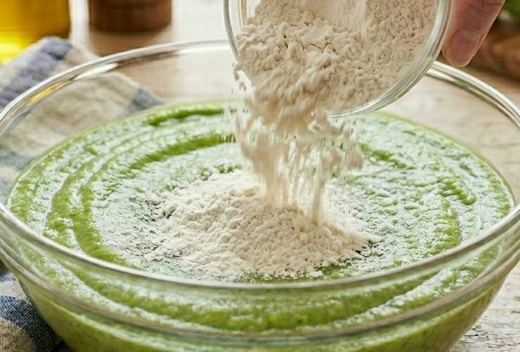 Uniamo il sale, il pepe e gli aromi che abbiamo scelto e mescoliamo ancora: io a volte aggiungo anche una spolverata di parmigiano grattugiato per dare più sapore e profumo. Setacciamo adesso nella crema la farina insieme al lievito istantaneo e accorpiamo al composto lavorando prima con un cucchiaio e poi direttamente con le mani;