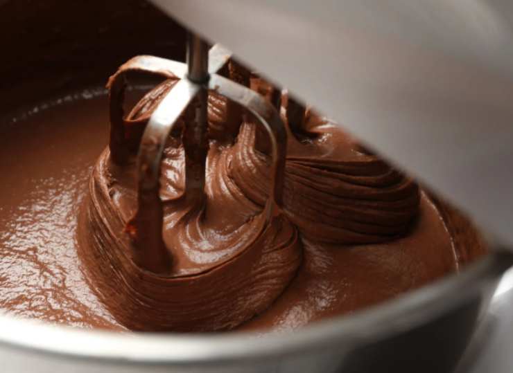 Mescoliamo la crema al cioccolato con il mascarpone (o la panna dolce montata a neve) usando un frullino. Riversiamo sulla base e livelliamo, quindi mettiamo in frigo un quarto d’ora ad assestare;