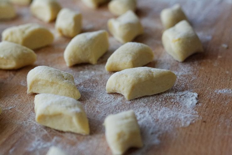 Tuffate gli gnocchi in acqua bollente salata e raccoglieteli con la schiumarola appena risalgono in superficie: versateli in una padella con il pesto, aggiungete un cucchiaio di acqua di cottura e mantecate bene creando un insieme avvolgente. Servite subito!