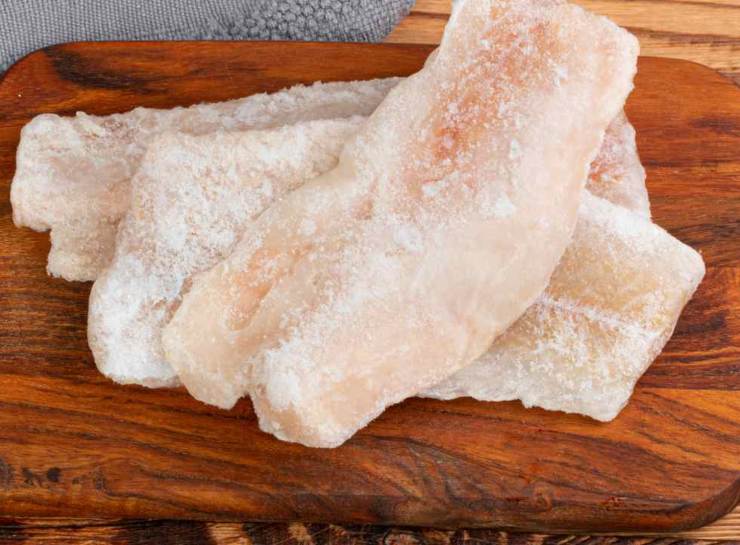 Scongelate il merluzzo in anticipo e tamponatelo con carta assorbente più volte in modo da eliminare ogni traccia di umidità. Grattugiate le patate crude a julienne usando una grattugia dai fori larghi, dividetele in due parti, mettetele in un canovaccio pulito e strizzate con tutta la vostra forza. Deve uscire ogni goccia d’acqua: più le patate sono asciutte, più diventeranno croccanti in cottura.