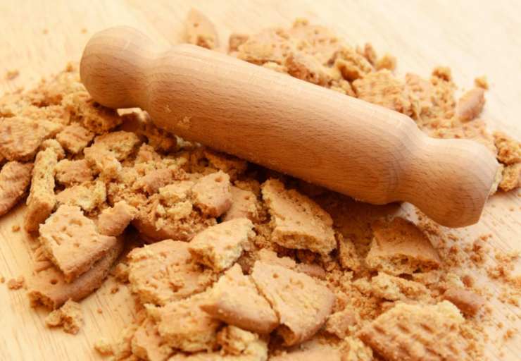 Sbricioliamo i biscotti secchi in una ciotola (possiamo fare un giro veloce in frullatore per velocizzare la preparazione), avendo cura di non ridurli in polvere. Aggiungiamo il cacao amaro setacciato e mescoliamo;