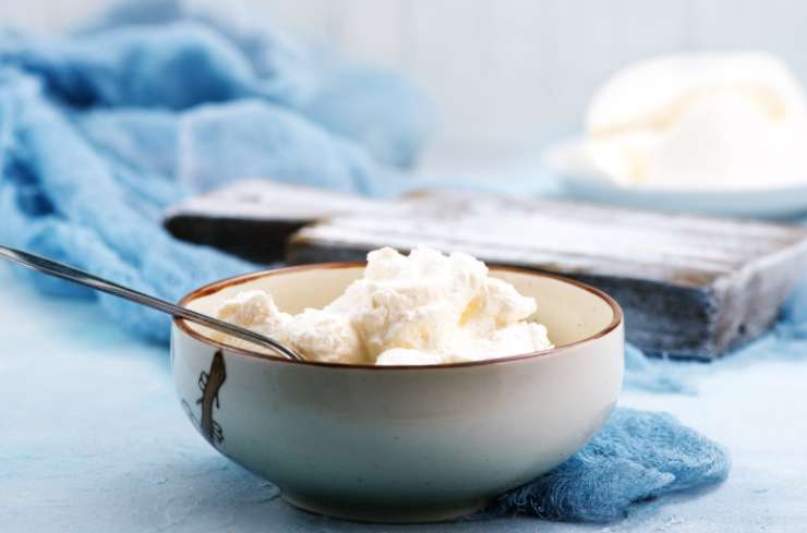 Iniziamo riversando la ricotta ben sgocciolata in una ciotola. Lasciamo ammorbidire a temperatura e poi uniamo lo zucchero;