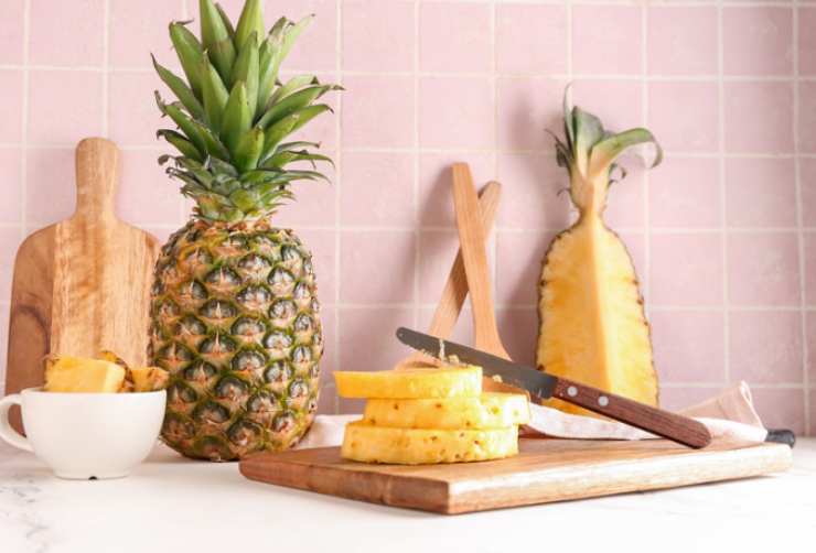 Iniziamo sbucciando l’ananas e tagliando a fettine di medio spessore: eliminiamo la parte centrale;