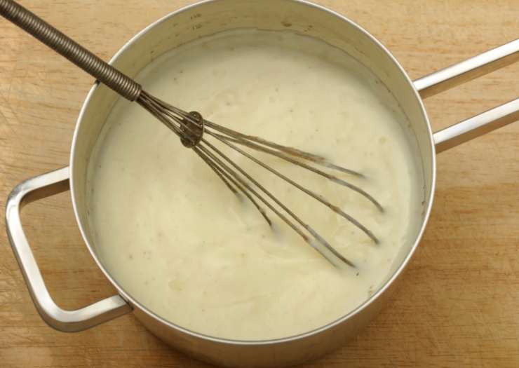 Iniziamo scaldando la besciamella (io uso quella comprata, ma voi se preferite potete farla a casa). Intanto dedichiamoci al sugo di pomodoro: rosoliamo la cipolla tritata in un tegame con un filo d’olio d’oliva e rosoliamo, quindi accorpiamo la passata e copriamo col coperchio, lasciando cuocere a fiamma dolce per mezz’ora rimescolando di tanto in tanto.