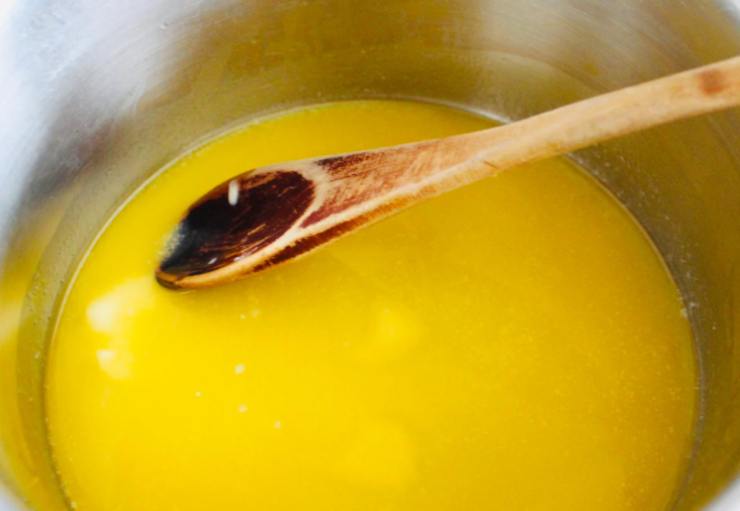 Riversiamo il burro in un tegame e sciogliamo a bagnomaria, quindi lasciamo raffreddare. Intanto sbucciamo le banane e tagliamole a pezzi, poi riduciamole in crema con una forchetta;