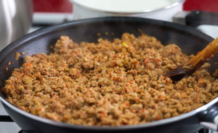 Iniziamo portando sul fuoco una padella antiaderente con un filo d’olio d’oliva e rosoliamo la mezza cipolla tritata. Uniamo la carne macinata, lasciamo dorare e sfumiamo con il vino bianco. Lasciamo cuocere per una ventina di minuti, rimescolando di tanto in tanto e tenendo la fiamma dolce;