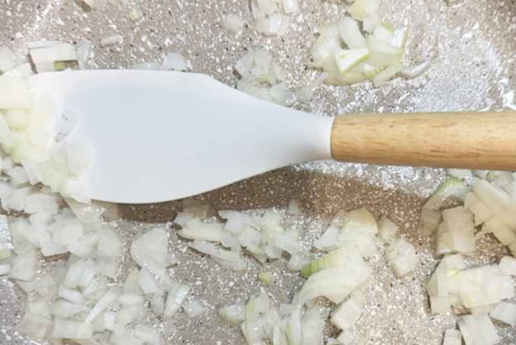 Portiamo sul fuoco la pentola riempita con l’acqua per cuocere la pasta e quando è a bollore saliamo e caliamo. In una padella antiaderente rosoliamo la mezza cipolla tritata con un filo d’olio d’oliva e lasciamo dorare.;