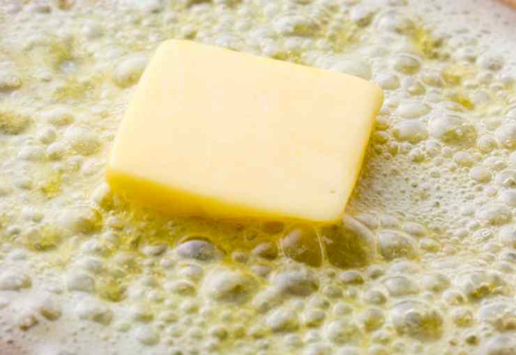 Sciogliamo il burro a bagnomaria e, intanto, frulliamo i biscotti al cacao per ridurli in briciole. Lasciamo intiepidire il burro e uniamolo ai biscotti, lavorando fino a ottenere un panetto simile alla pasta frolla;