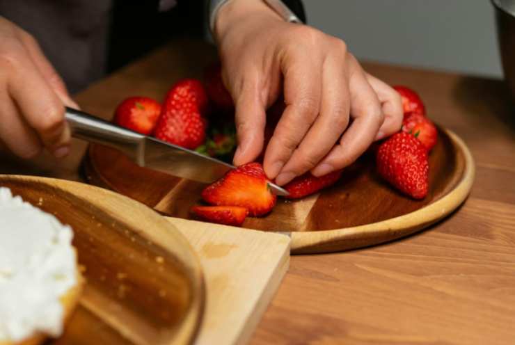 Laviamo e tagliamo le fragole a pezzetti, riversiamole in una ciotola e condiamo con il succo di limone e lo zucchero. Mescoliamo e lasciamo macerare per mez’ora;