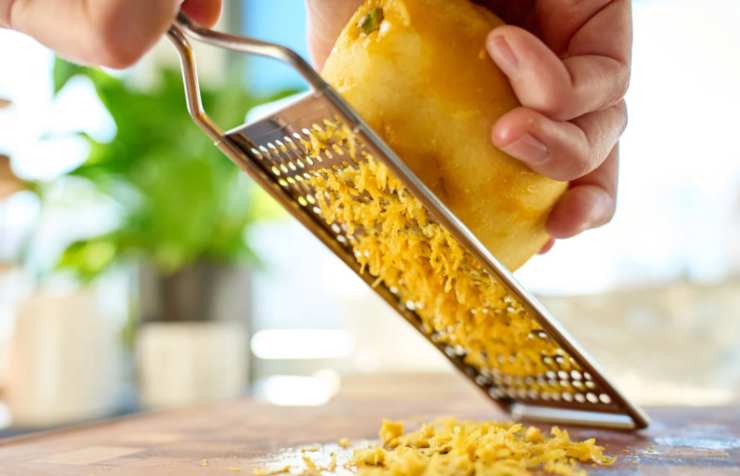 Laviamo le arance e il limone e grattugiamo la buccia. Rompiamo le uova in una ciotola e uniamo lo zucchero, la vanillina e le bucce e lavoriamo con un frullino;