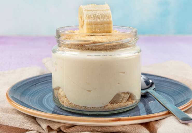 Riprendiamo la crema trascorsa una mezz’ora. Prepariamo dei bicchieri o delle coppette e sul fondo versiamo la granella di biscotti. Ricopriamo con cucchiaiate di crema quasi fino in cima e poi decoriamo con la frutta che preferiamo (io stavolta ho usato banane a pezzi). Non resta che gustare!