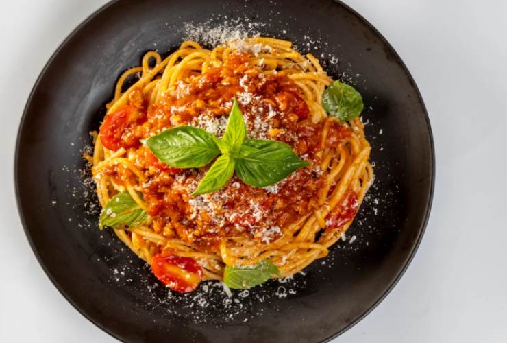 Portiamo sul fuoco la pentola con l’acqua per la pasta e una volta a bollore caliamo. Scoliamo appena cotta e riportiamo in pentola. Condiamo con coppini di sugo di pomodoro e carne e con una spolverata di parmigiano. Distribuiamo nei piatti e ricopriamo col sugo rimasto.