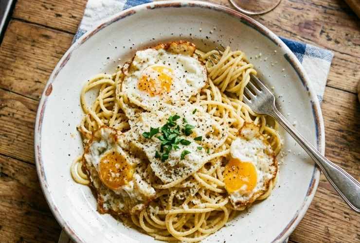 Scoliamo la pasta appena al dente tenendo da parte un mestolo di acqua di cottura. Versiamo la pasta nella padella con le uova e, con l’aiuto di una forchetta o di una spatola, rompiamo i tuorli. Aggiungiamo il parmigiano grattugiato e l’acqua di cottura quindi mescoliamo a fiamma vivace per creare una sorta di cremina. Spegniamo il fuoco, aggiustiamo il sale e spolveriamo con gli aromi che preferiamo: pronti per correre a tavola.