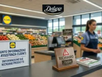 Punto informazioni LIDL con cartello di richiamo prodotto per il marchio Deluxe e segnale di attenzione.