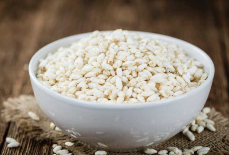 Andiamo intanto a unire al cioccolato rimasto il riso soffiato e mescoliamo per distribuire. Quando chicchi saranno mescolati alla crema di cioccolato riprendiamo la teglia e riversiamo il composto, livellando;