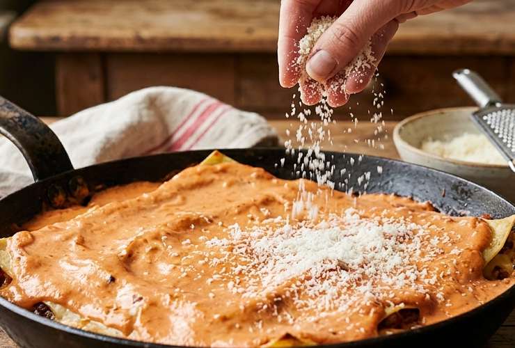 Prepariamo una padella antiaderente dai bordi alti e sul fondo versiamo tre o quattro coppini di sugo. Adagiamo le prime sfoglie di lasagna, la mozzarella a pezzetti e ricopriamo con un paio di cucchiai di sugo. Spolveriamo metà del pangrattato e ricopriamo col resto delle sfoglie di lasagna;