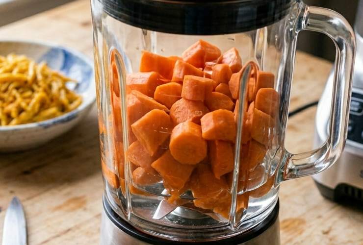 Portiamo a bollore una pentola d’acqua leggermente salata e cuociamo le carote finché non risultano tenere. Scoliamole e sgoccioliamole, quindi riversiamole nel boccale del frullatore e iniziamo a lavorarle;