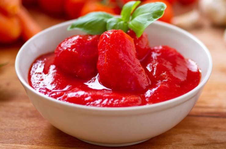 Uniamo quindi i pomodori pelati dopo averli schiacciati un po’ con una forchetta. Accorpiamo le olive denocciolate e gli aromi scelti. Copriamo il tegame con un coperchio e abbassiamo la fiamma, lasciando cuocere per circa 40 o 50 minuti, mescolando di tanto in tanto e aggiungendo un goccio di acqua all’occorrenza;