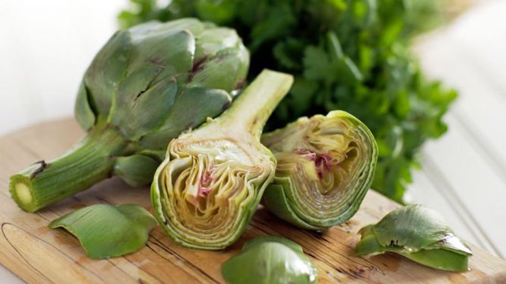 Pulite i carciofi eliminando le foglie dure e la barba interna, tagliateli a fettine sottilissime. In una padella scaldate un giro d’olio extra vergine d’oliva con l’aglio pelato, unite i carciofi e saltateli a fiamma viva. Sfumateli con il vino bianco, salate, pepate quindi fate cuocere con un coperchio per 10 minuti aggiungendo un filo d’acqua se serve: devono diventare quasi burrosi.