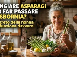 Una simpatica nonna in cucina mostra un mazzo di asparagi freschi come rimedio naturale per far passare la sbornia e depurare il fegato.