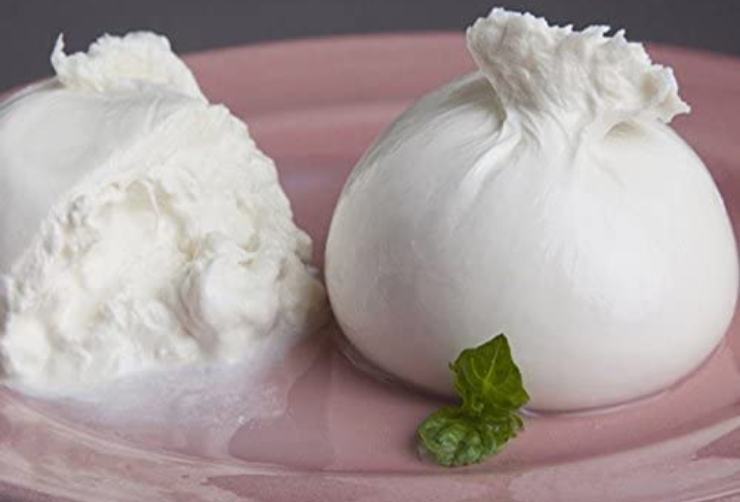 Mentre la pasta cuoce, prendete la burrata fresca e sfilacciatela delicatamente separando la stracciatella interna e tagliando a striscioline la parte esterna. Rimuovete lo spicchio d’aglio dalla ciotola dei pomodori, che nel frattempo avranno rilasciato un delizioso sughetto profumato e saporito sul fondo.