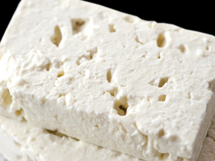 Sbriciolate la feta direttamente con le mani sopra la pasta, lasciando cadere sia pezzi piccoli che frammenti più grossi per creare consistenze diverse. Coprite l’insalatiera con la pellicola trasparente e lasciatela riposare al fresco in frigo per almeno mezz’ora prima di servire in tavola con un ultimo filo d’olio a crudo. Buon appetito!