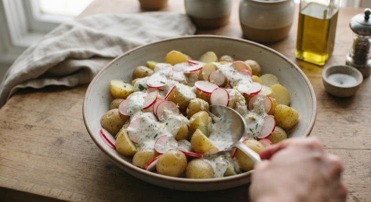 Prendete le patate novelle ormai fredde e tagliatele semplicemente a metà o in quattro parti se qualcuna fosse più grande. Trasferitele in un’ampia insalatiera, unite le fettine di ravanello e versate sopra la salsa allo yogurt. Mescolate il tutto con estrema delicatezza dal basso verso l’alto. Riponete l’insalata in frigorifero per almeno 20 minuti prima di servirla, così da permettere alle patate di assorbire tutti gli aromi e gustatela!