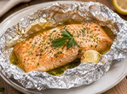 Salmone al cartoccio appena cotto e servito con prezzemolo e limone