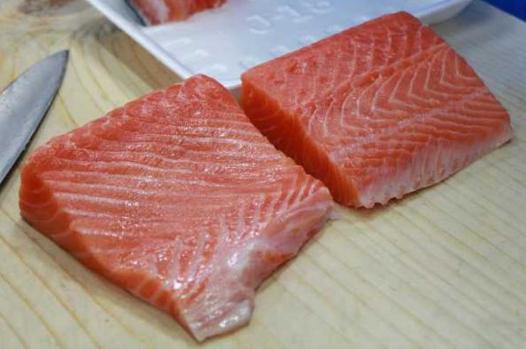 Adagiate il filetto di salmone fresco su un tagliere pulito. Utilizzando un coltello ben affilato, riducete il pesce prima a striscioline e poi in piccoli cubetti regolari di pochi millimetri, battendo la polpa con delicatezza fino ad ottenere un trito grossolano. Trasferitelo in una ciotola capiente, aggiungete lo zenzero fresco grattugiato, la scorza grattugiata di lime, un pizzico di sale e pepe ed il pangrattato.&nbsp;