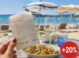 Scontrino di un pranzo in spiaggia con aumento dei prezzi del 20%, piatto di pasta e ombrelloni sullo sfondo