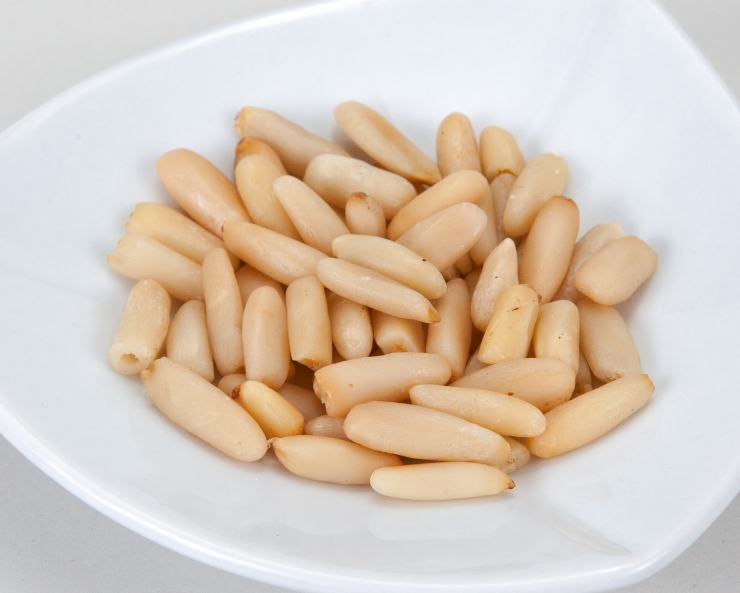 Fatto ciò trasferiteli ben puliti nel mixer insieme ai pinoli (tenendone da parte qualcuno per decorare), il basilico, il pecorino, un pizzico di sale e l’olio. Frullate fino ad ottenere una crema liscissima. Lessate la calamarata in abbondante acqua salata e mentre la pasta cuoce, tostate i pinoli rimasti in un padellino.