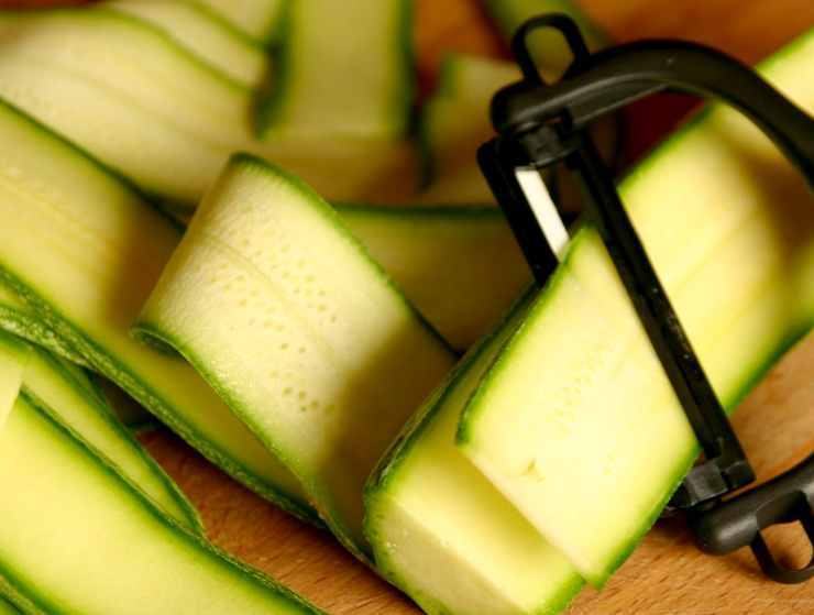 Nel frattempo, lavate le zucchine e tagliatele verticalmente a strisce sottili. Trasferitele in una ciotolina e conditele con due cucchiai di olio extravergine d’oliva, il succo di mezzo limone, un pizzico di sale e le foglie di menta fresca. Lasciate marinare a crudo per 10 minuti affinché si ammorbidiscano restando croccanti.