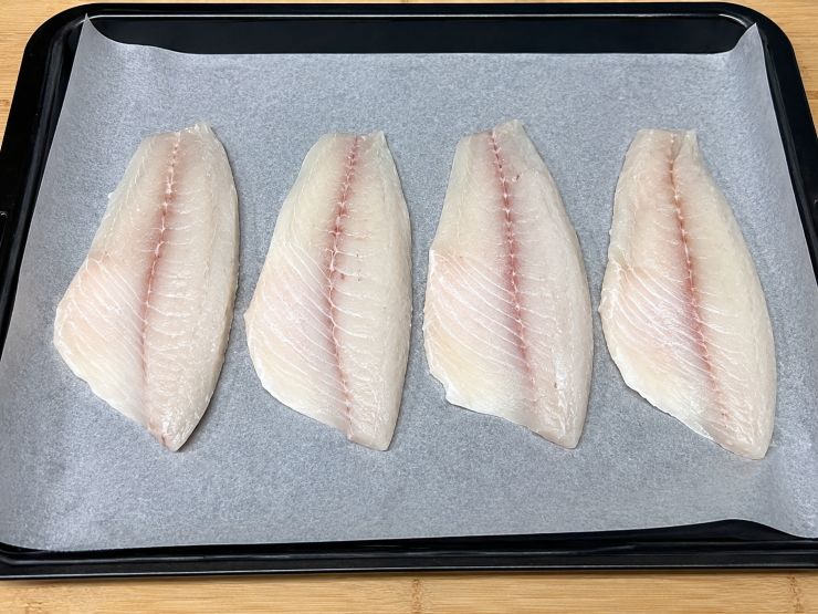 Prendete i filetti di orata, controllate con una pinzetta l’assenza di lische residue e tamponateli ripetutamente con carta da cucina su entrambi i lati fino a quando la superficie risulterà completamente asciutta. Foderate una teglia capiente con carta forno ed ungetela con un filo d’olio extra vergine d’oliva. Adagiate i filetti di orata con la pelle rivolta verso il basso. Salate e pepate leggermente la polpa, poi distribuitevi sopra le olive taggiasche sminuzzate e un pizzico di rosmarino tritato.