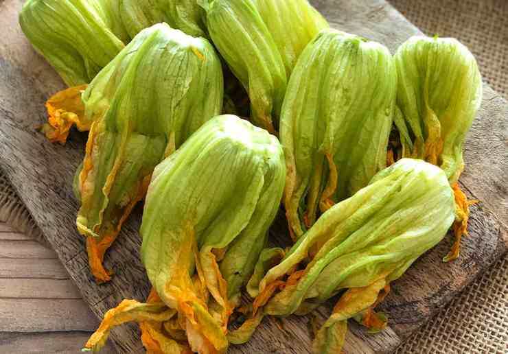 Portate a bollore una capiente pentola di acqua salata e calate gli spaghetti. Intanto pulite i fiori di zucca con estrema delicatezza: rimuovete il gambo, i filamenti laterali esterni ed il pistillo interno. Passateli rapidamente sotto un filo d’acqua fredda o strofinateli delicatamente con un panno umido, poi asciugateli bene con carta assorbente.
