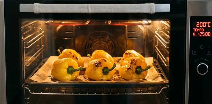 Preriscaldate il forno a 200 gradi: lavate i peperoni, asciugateli e disponeteli interi su una teglia foderata di carta forno. Cuoceteli per circa 25 minuti, girandoli a metà cottura finché la pelle apparirà abbrustolita. Appena sfornati, infilateli ancora bollenti in un sacchetto di plastica per alimenti e chiudetelo stretto. Lasciateli riposare per 10 minuti, poi aprite: noterete che la buccia si staccherà dai peperoni con estrema facilità.