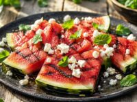 Fette di anguria alla brace grigliate con feta sbriciolata e menta fresca